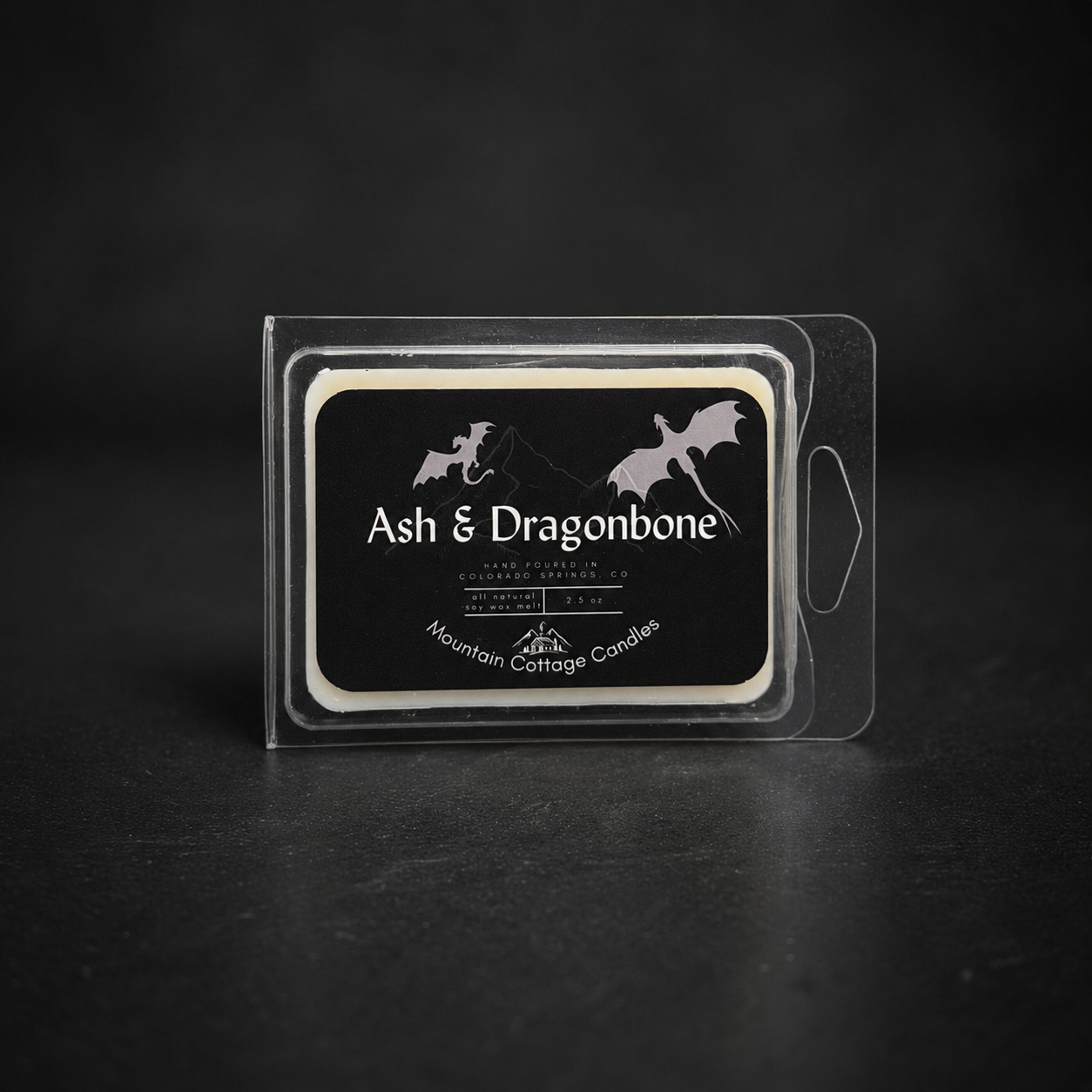 Ash & Dragonbone soy wax melt in a clear clamshell pack, black label showing two dragons in flight