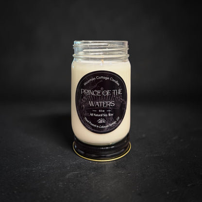 Prince of The Waters soy candle in a clear glass jar with a black lid, black label showing an ornate crown