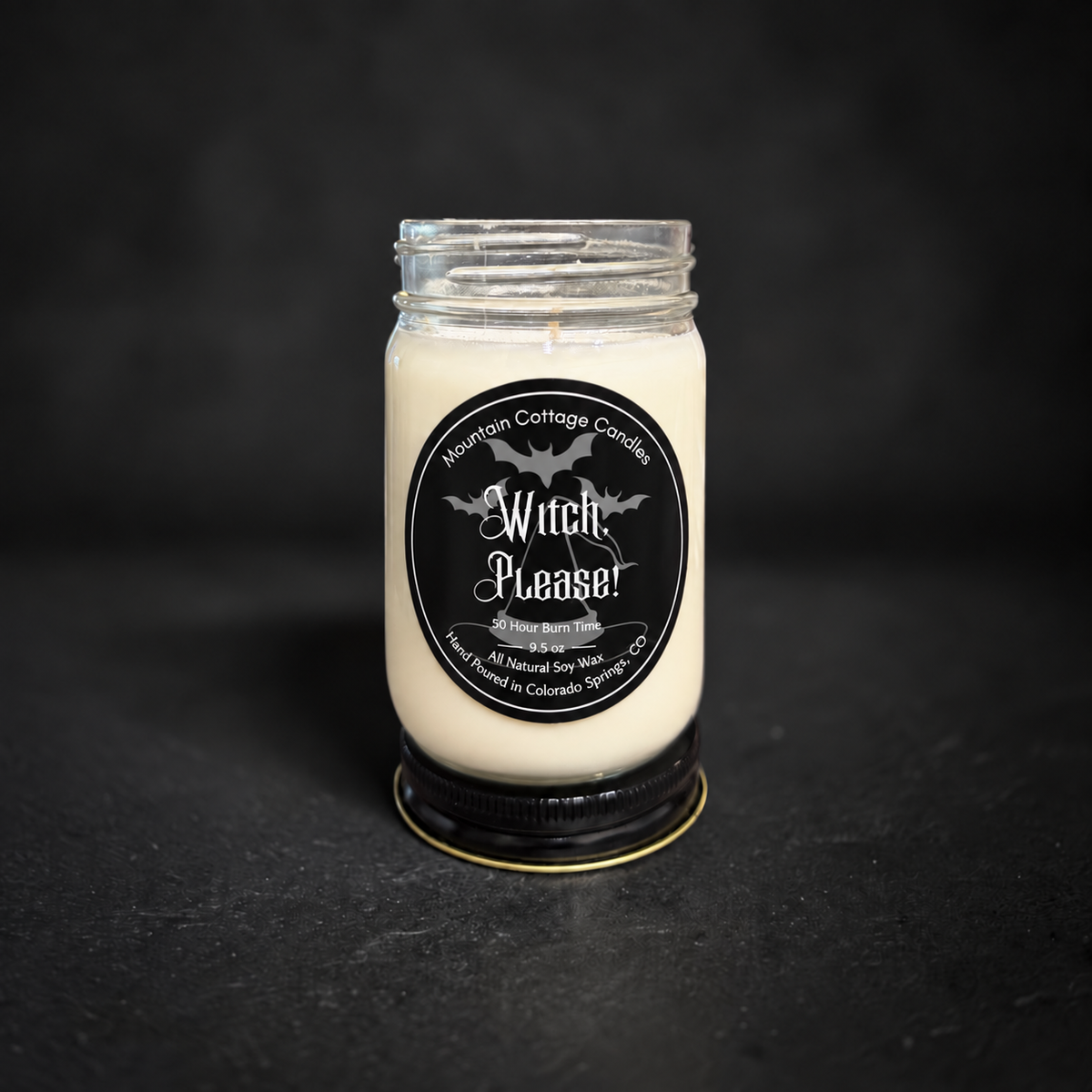 Witch, Please! soy candle in a clear glass jar with a black lid, black label with flying bats above a witch's hat